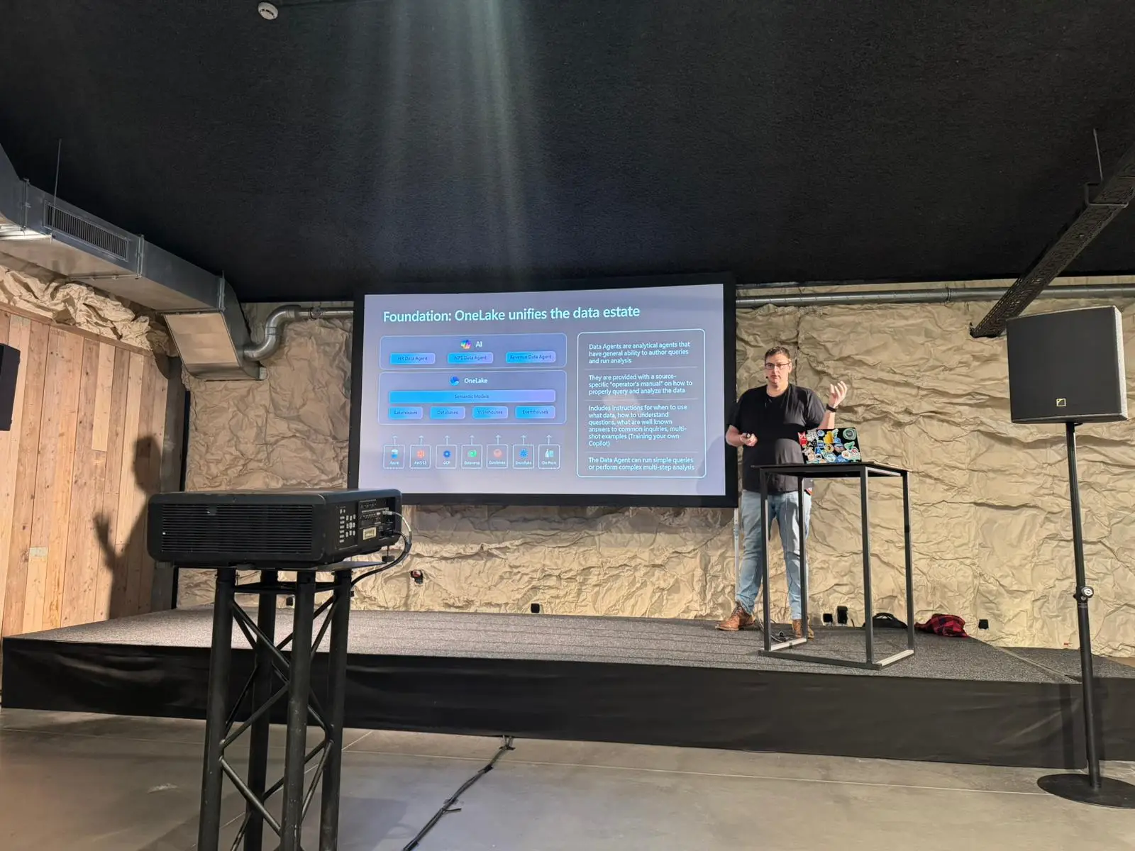 A speaker at the lectern presenting a technical session